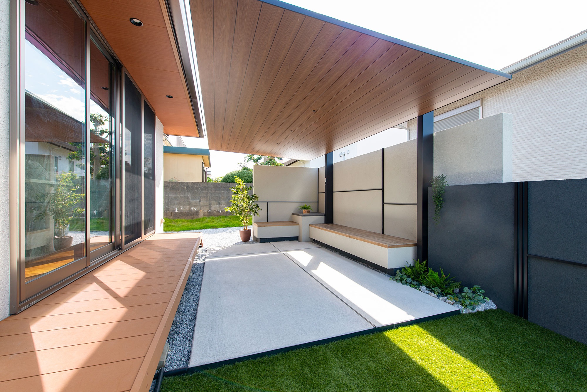テラス屋根とベンチの快適な庭空間